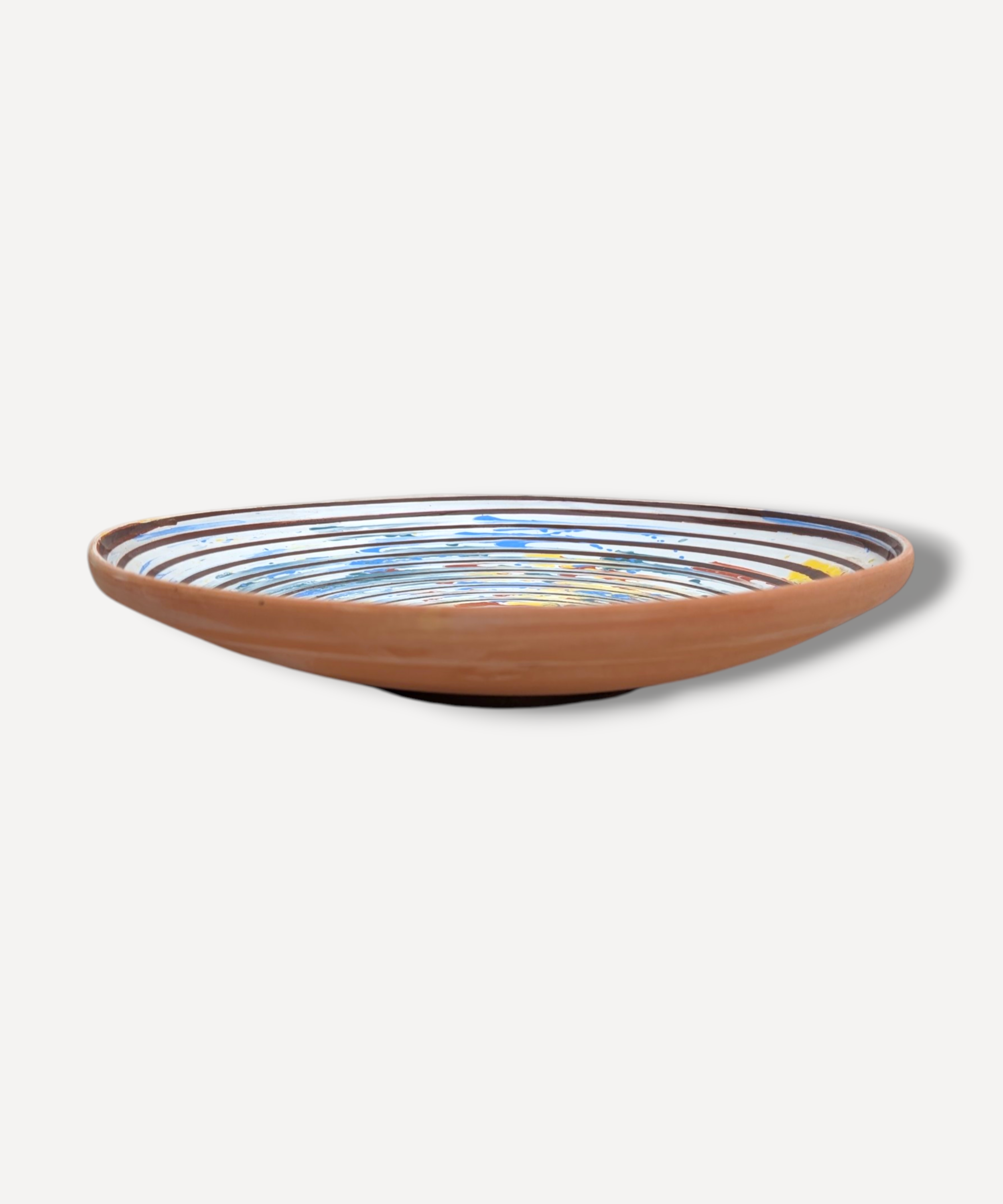 Hand decorated Romanian ceramic platter with spiral folk pattern in blue ochre and terracotta tones