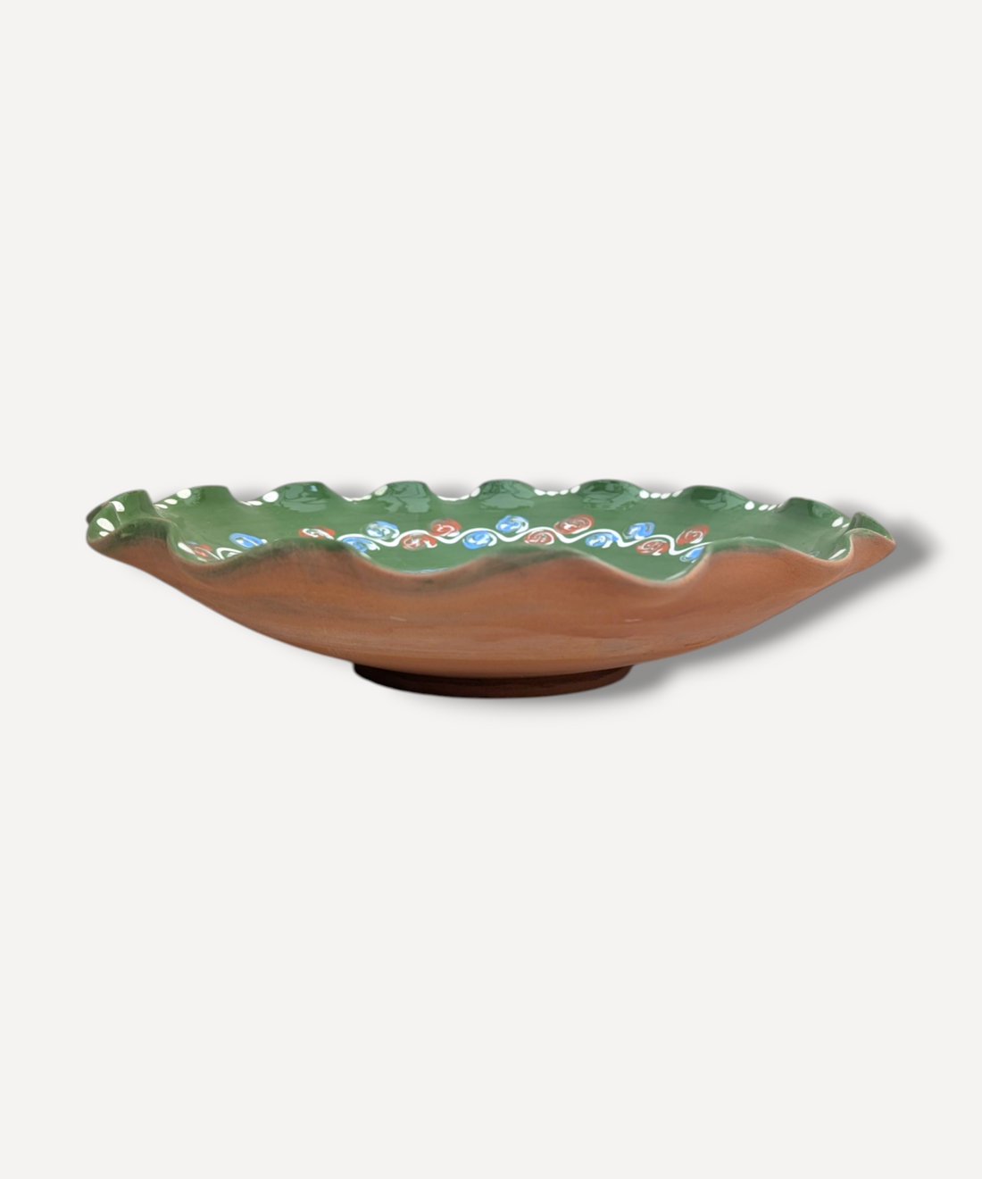 Ceramic plate with green rim and floral patterns on a white background