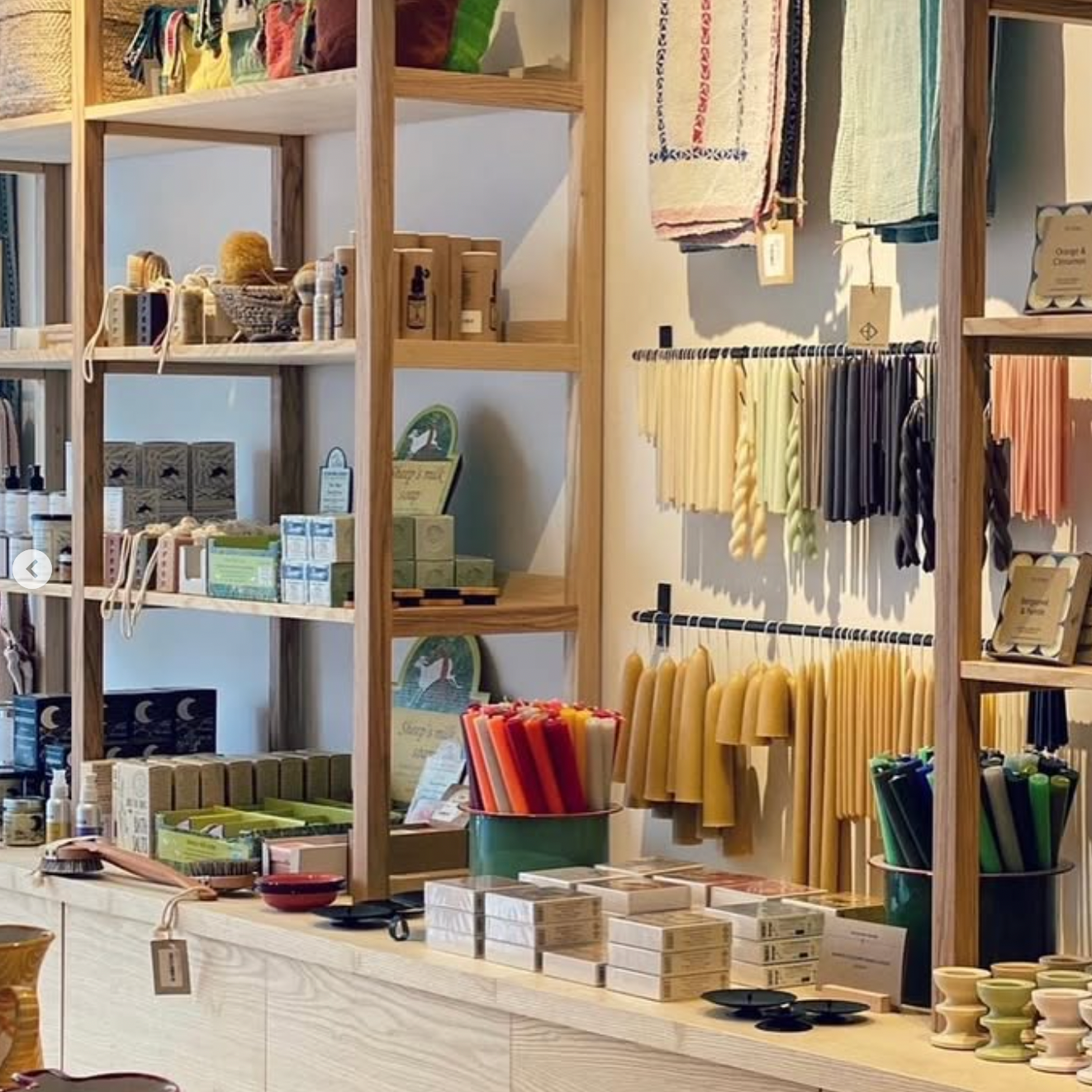 Store interior with shelves displaying various products and a counter with more items.