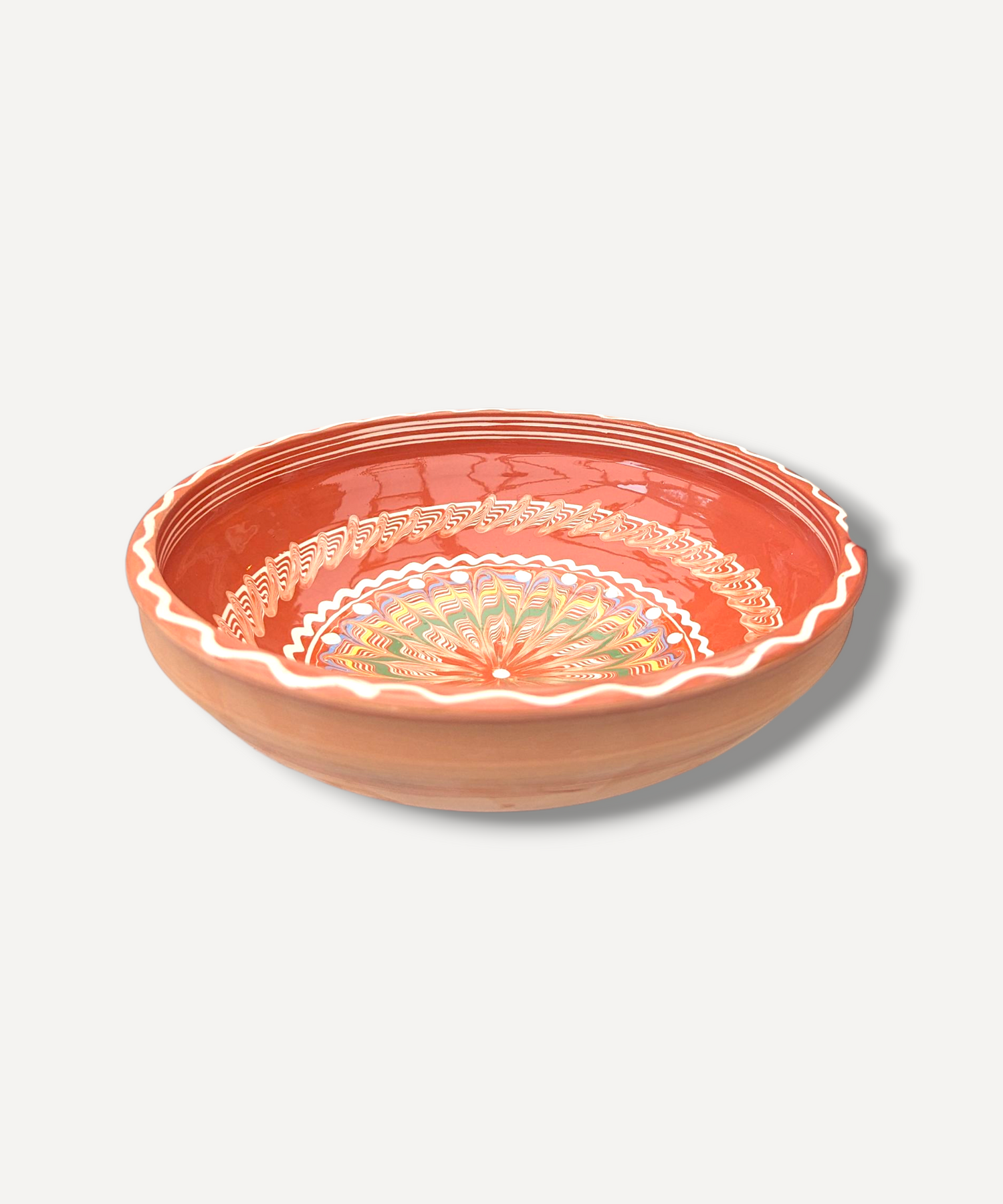 Handcrafted earthenware bowl with floral patterns on a light gray background