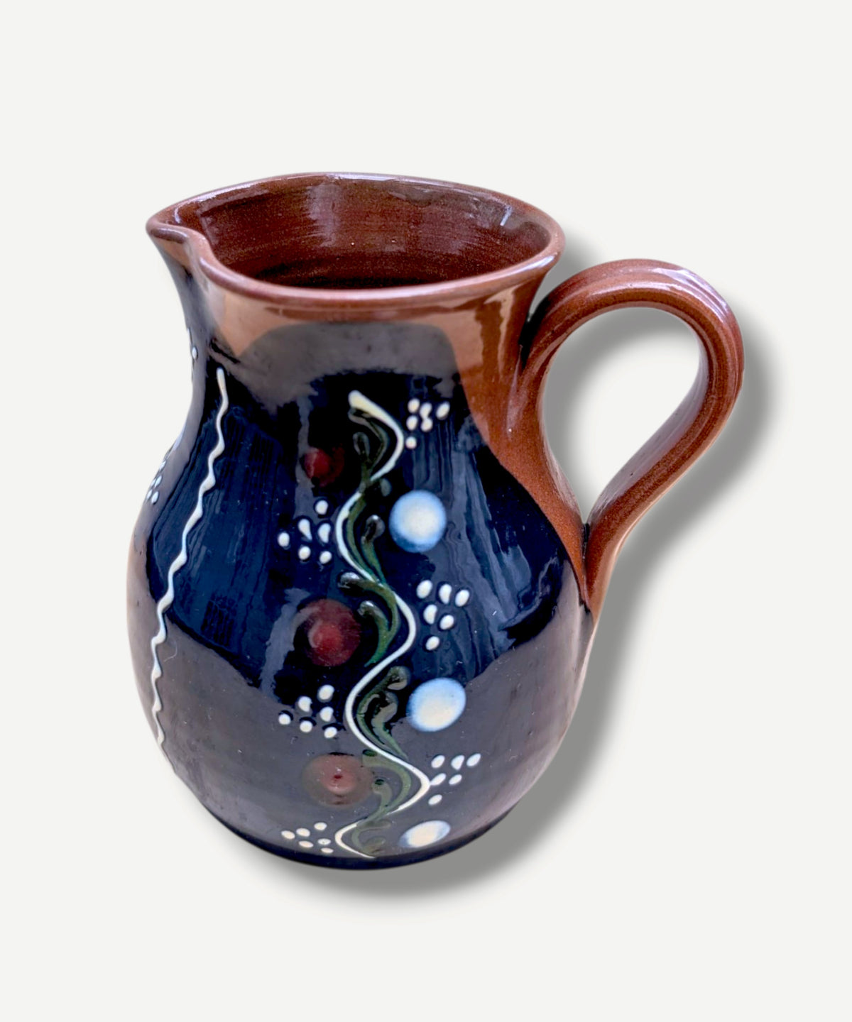 Handmade cobalt-blue Romanian earthenware jug with vertical white wavy lines, dotted motifs and a chocolate-brown rim.