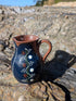 Handmade cobalt-blue Romanian earthenware jug with vertical white wavy lines, dotted motifs and a chocolate-brown rim.