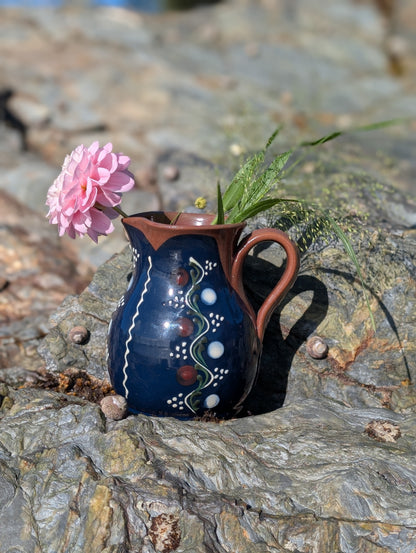 Handmade cobalt-blue Romanian earthenware jug with vertical white wavy lines, dotted motifs and a chocolate-brown rim.