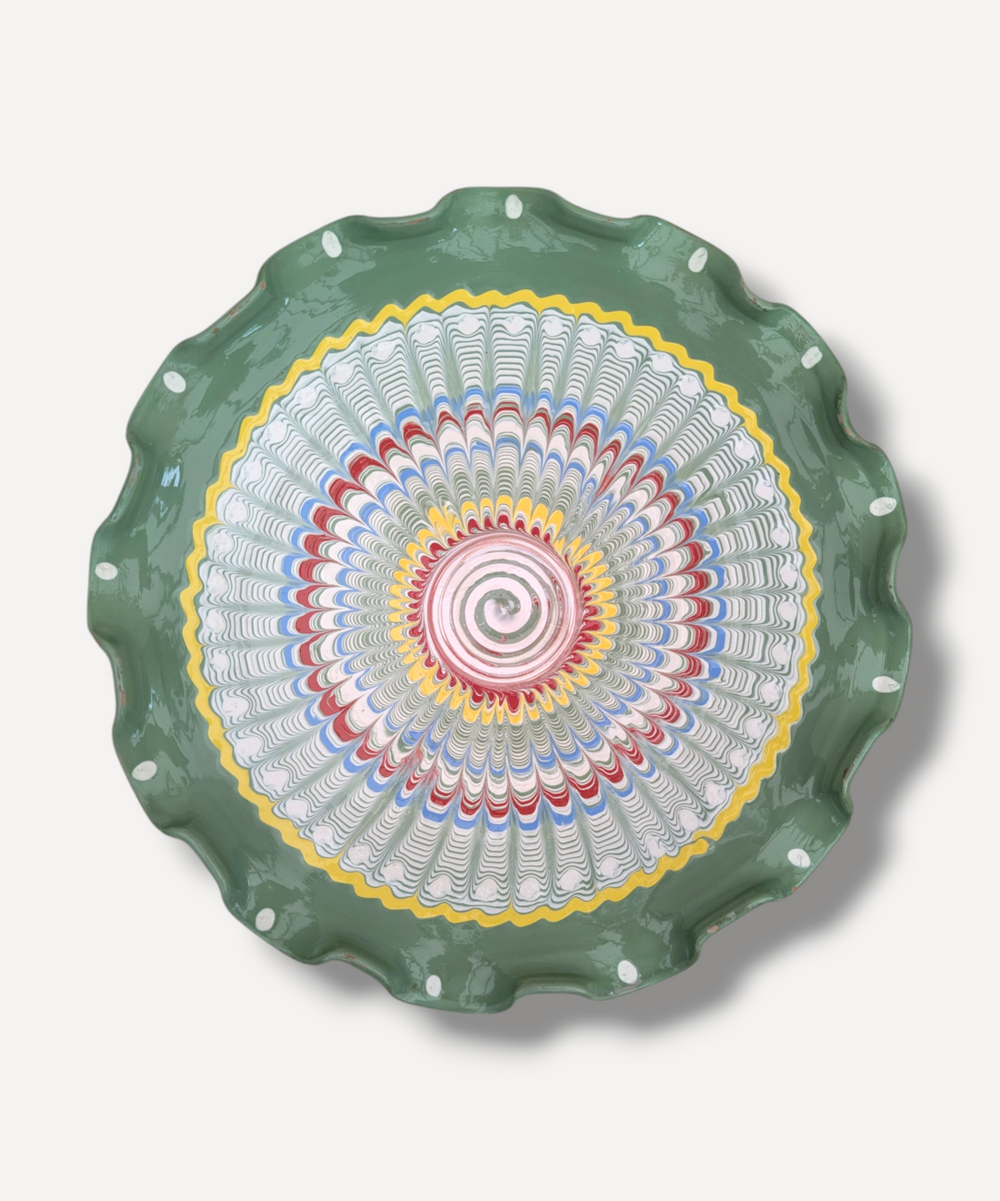 Decorative plate with a colorful spiral design on a green rim against a white background