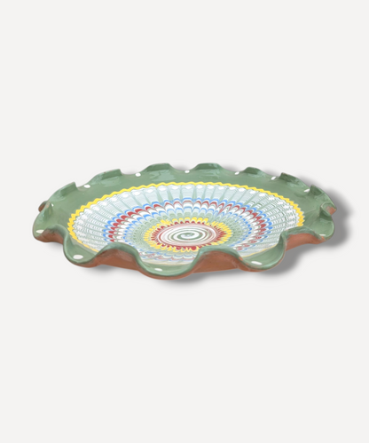 Decorative ceramic plate with colorful concentric circle design on a white background
