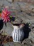Handmade white Romanian earthenware vase with cobalt-blue wavy lines and dotted motifs and a brown interior.