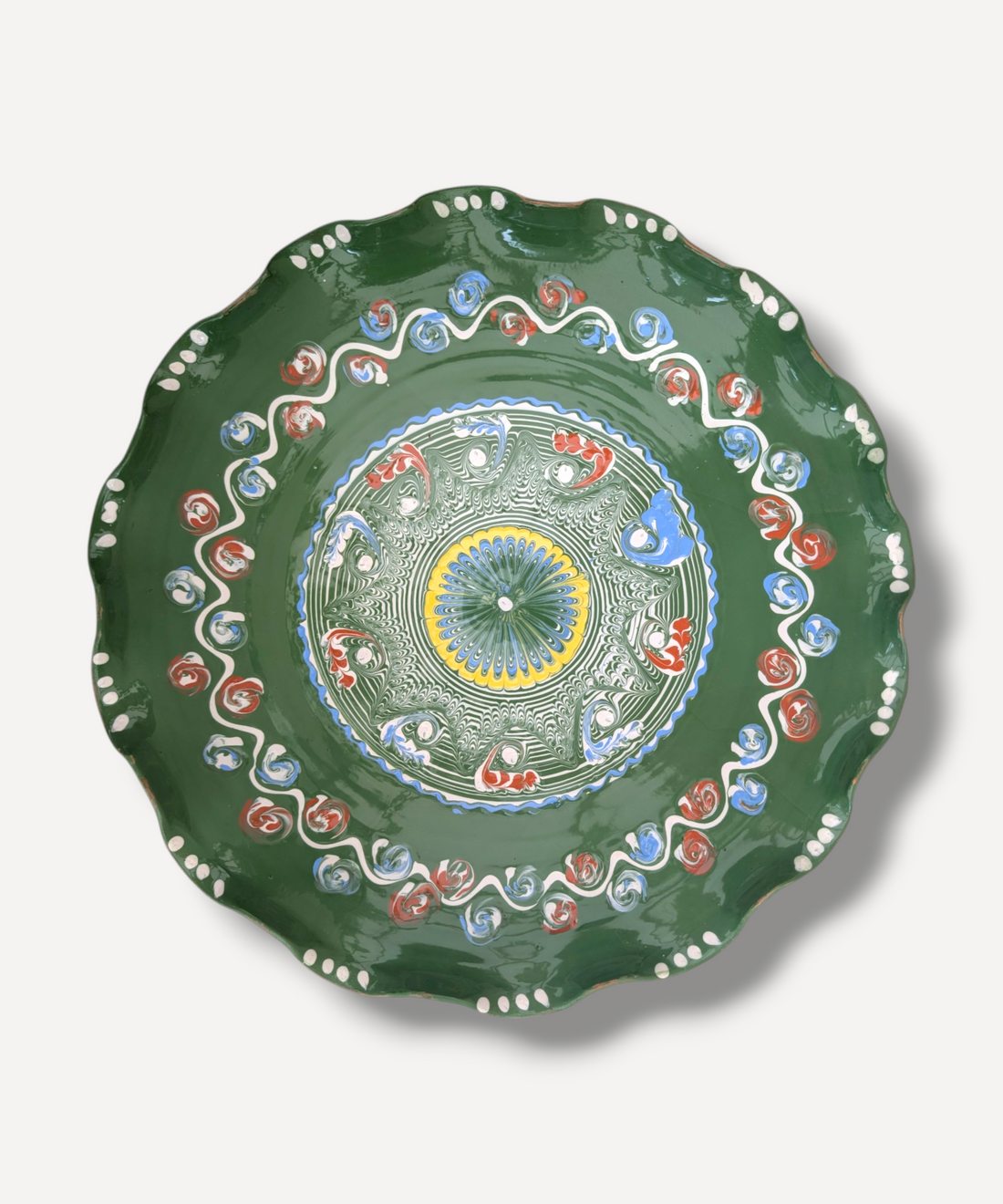 Decorative green plate with colorful patterns on a white background