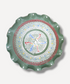 Decorative plate with a green rim and colorful center on a white background