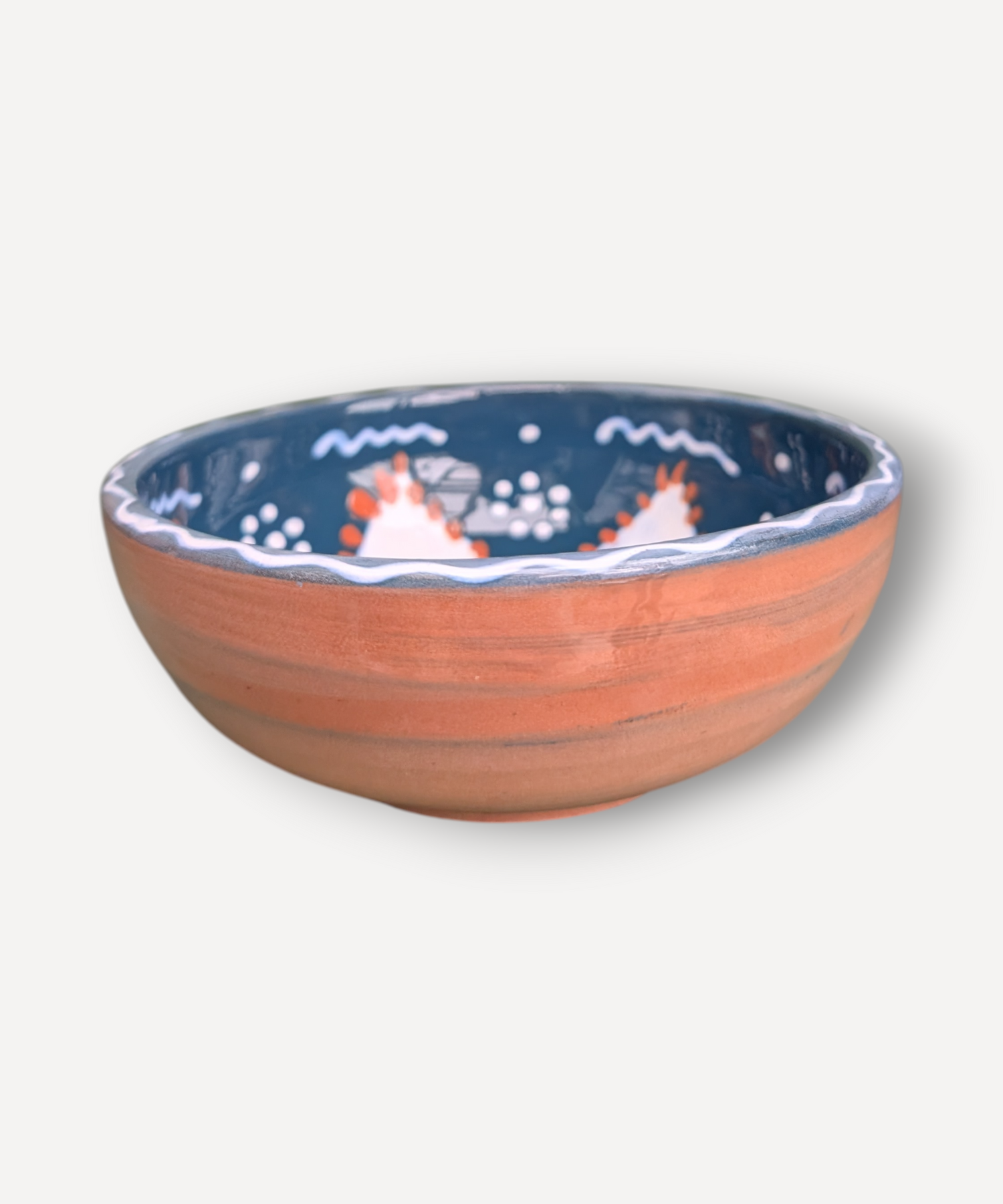 Ceramic bowl with blue rim and decorative elements on a white background