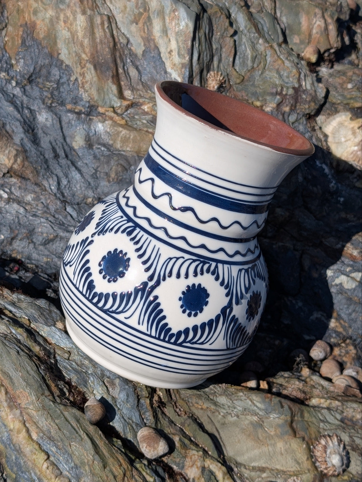 Casa De Folklore Handmade white Romanian earthenware vase with cobalt-blue wavy lines and dotted motifs and a brown interior.
