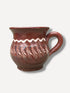 Handmade dark chocolate Romanian ceramic mug with traditional folk decoration on outdoor café table