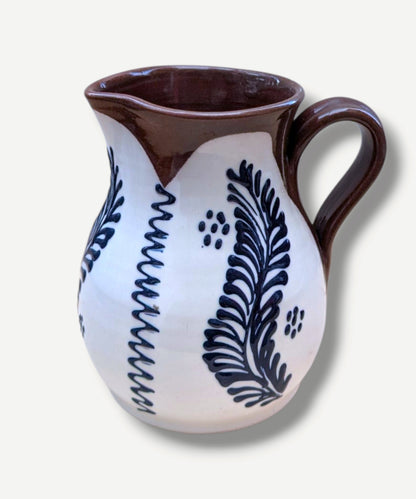 Handmade white Romanian earthenware jug with cobalt blue botanical motifs and a chocolate-brown rim and handle. By Casa De Folklore 

