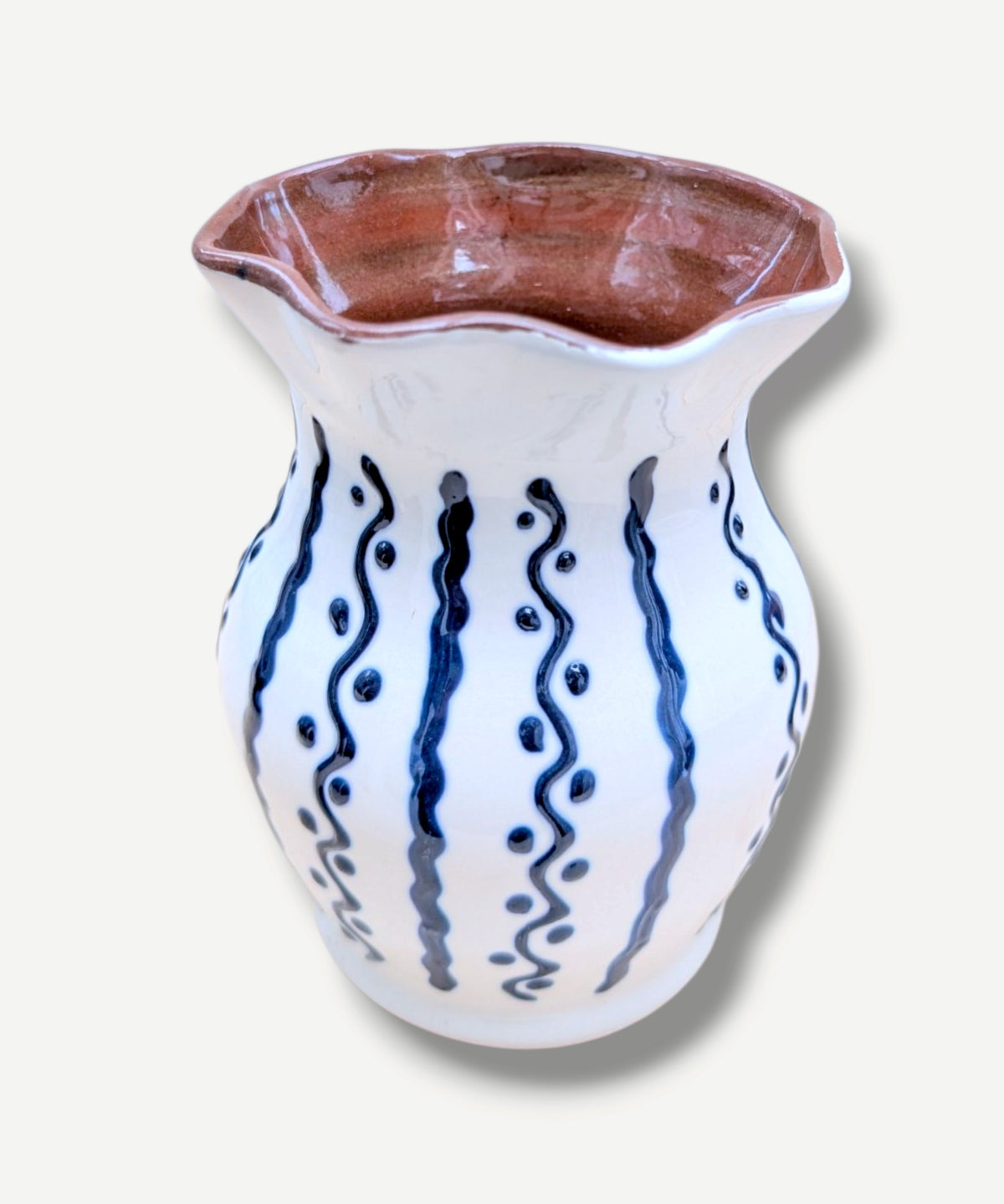 Handmade white Romanian earthenware vase with cobalt-blue wavy lines and dotted motifs and a brown interior.