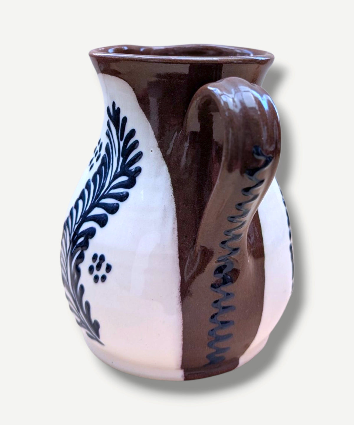 Handmade white Romanian earthenware vase with cobalt blue floral motifs, a rounded body and a sculptural narrow waist. By Casa De Folklore 